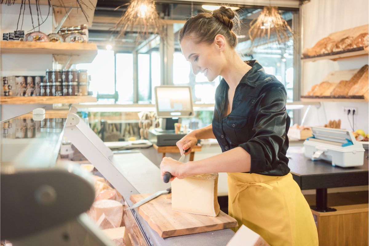 Seller in deli slicing cheese