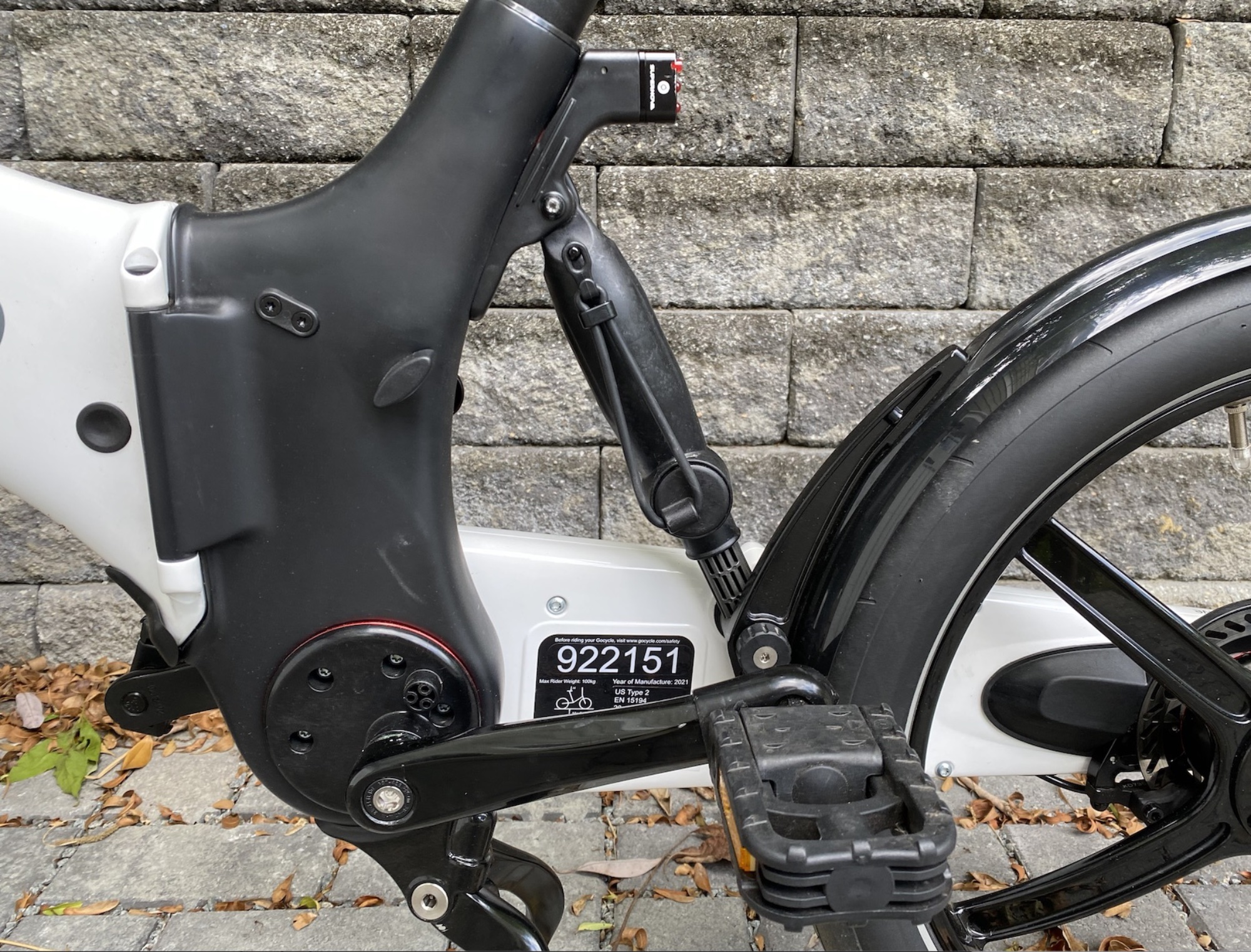 A close-up of the rear suspension.  Note the elastic band stored on it - when the bike is folded, it clips onto a hook on the handlebars to keep it folded.  Also note the black plastic handle on the left side, which can be rotated to release the seatpost for storage.