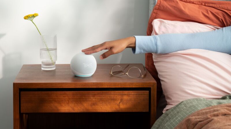 An Amazon Echo Dot on a bedside table.