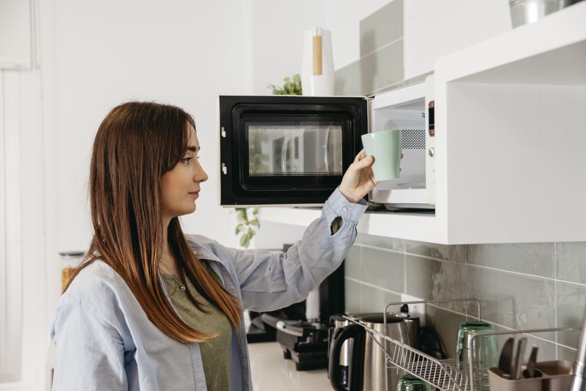 Casual girl with microwave warming mug