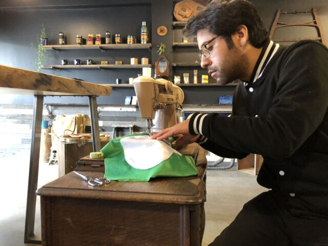 Roberto Hoyos sews a pillow.