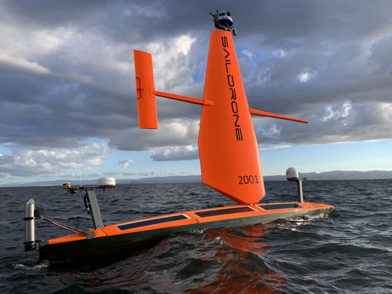 Image of a thin floating orange board with a sturdy upright wing and solar panels.