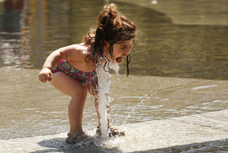 A 2-year-old enjoys splashing water at a splash pad in Los Angeles on June 20, 2022.