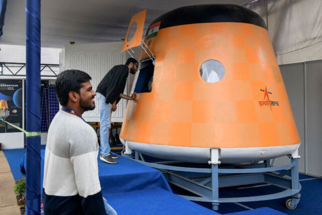 Visitors look at a real scale model of India's Gaganyaan Orbital Module, a human-rated spacecraft now under development, at the 2022 Human Space Flight Expo.