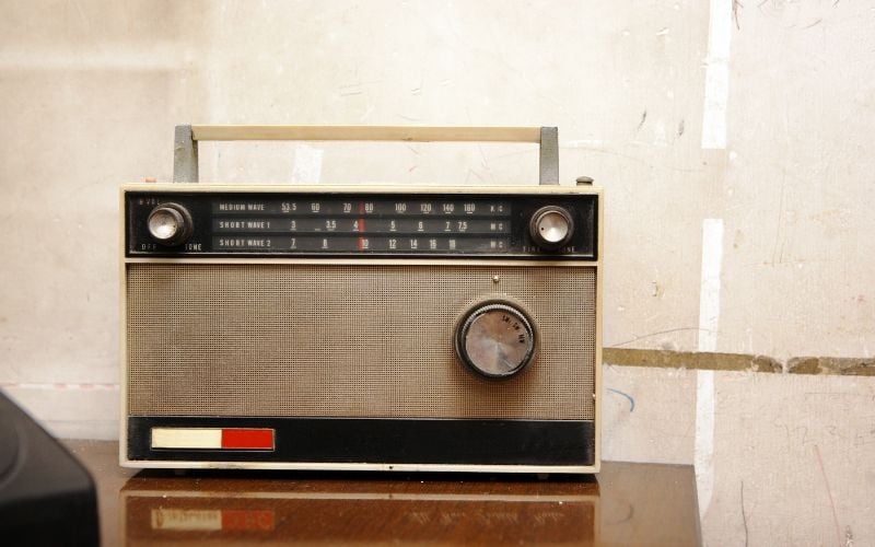 Boxy radio in front of a scratched wall