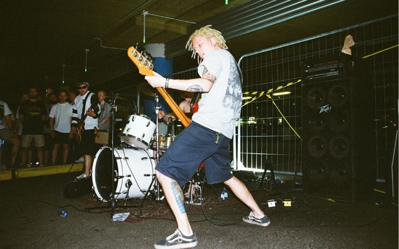 Canadian radio punk artist playing guitar on stage 