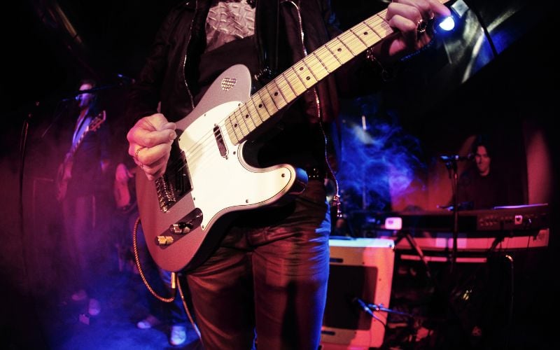 Rock band on stage playing guitar with colorful stage lights