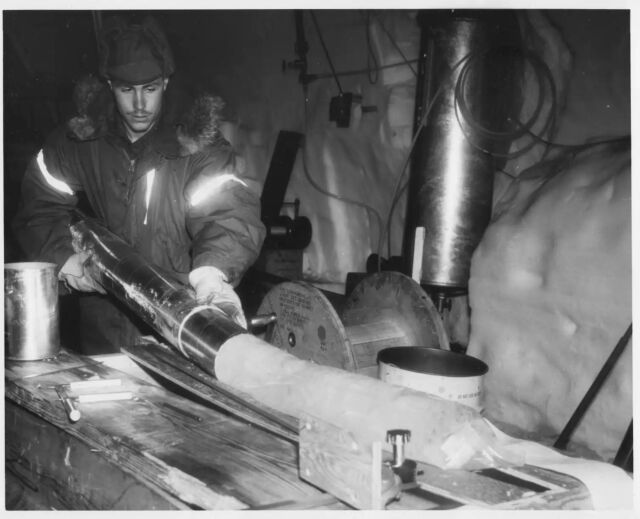 George Linkletter, who works for the US Army Corps of Engineers Cold Regions Research and Engineering Laboratory, examines a piece of ice core in the science trench at Camp Century.  The base was shut down in 1967.