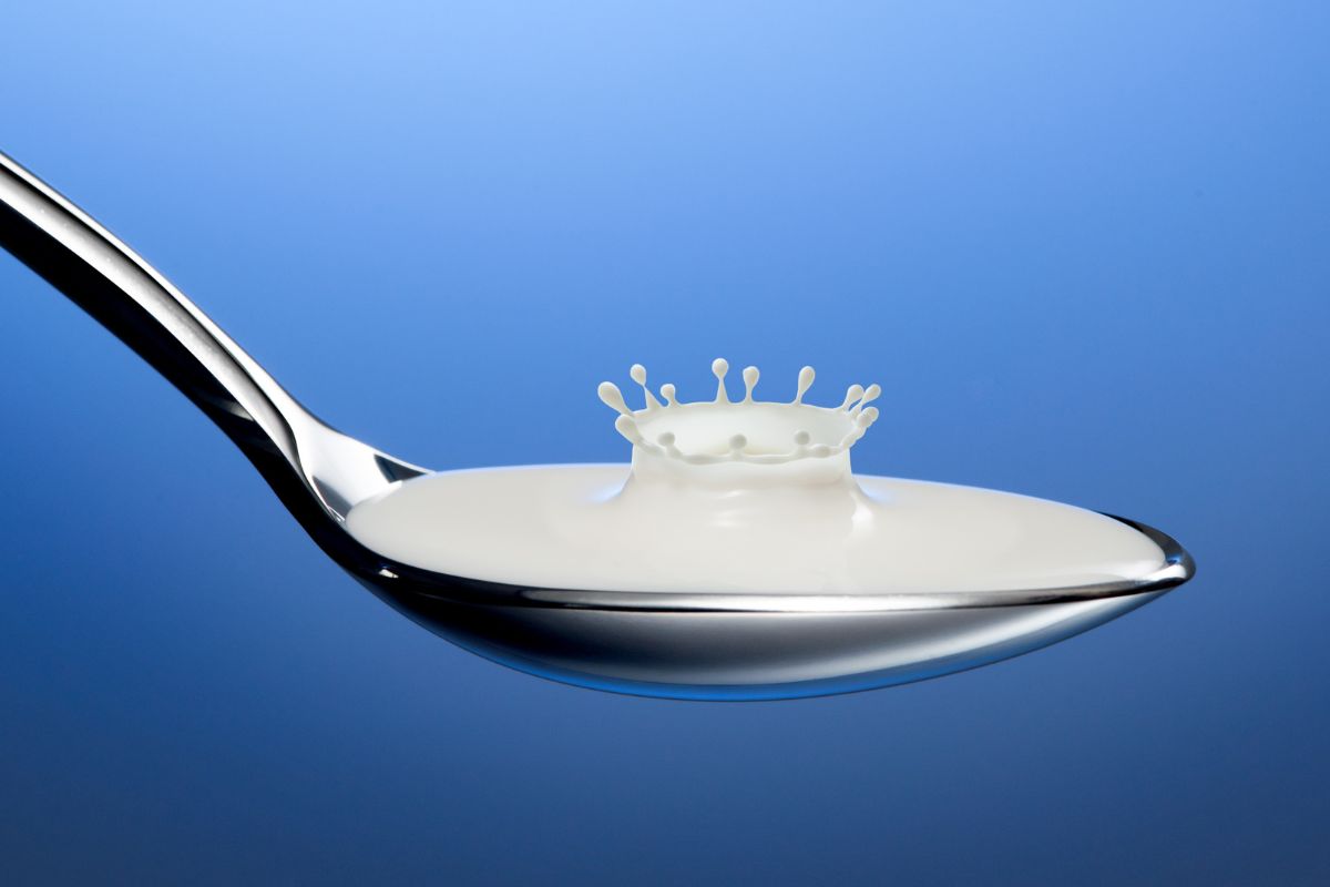 Spoon with splashing milk