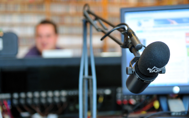 Radio presenter in the background with a microphone in the foreground