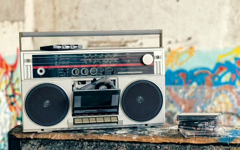 Old-school radio with a stack of cassettes in front of a graffiti-painted wall in New York City