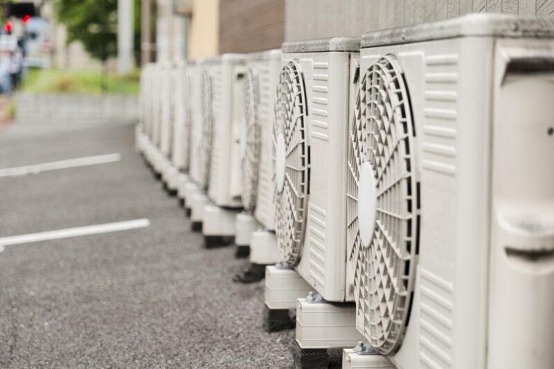 A row of gray metal boxes with built-in fans, used as air conditioners.